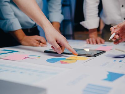 Millennial Asia businessmen and businesswomen meeting brainstorming ideas about new paperwork project colleagues working together planning success strategy enjoy teamwork in small modern night office.