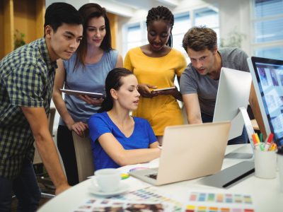 Graphic designers discussing over laptop in the office