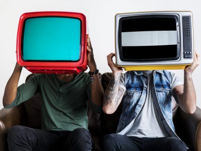 People holding retro television next to each other